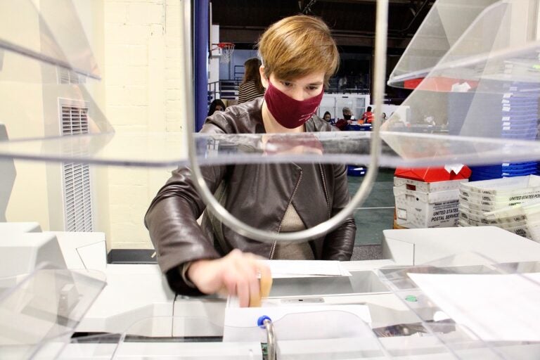 Margaret Hodgkiss-Lilly operates an extractor, which removes ballots from their envelopes