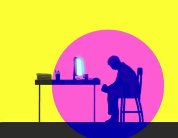 Depressed man sitting in front of glowing computer screen.