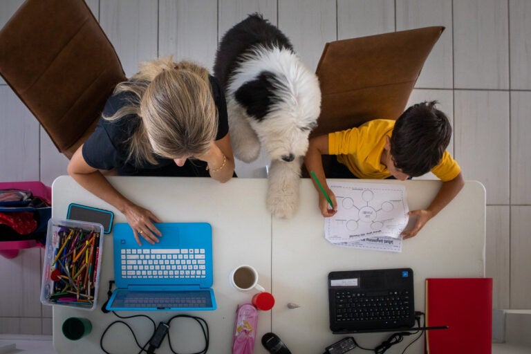 A mother works from home while her son attends school remotely