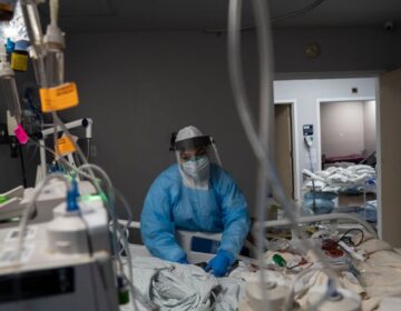 A health care worker treats a COVID-19 patient at the ICU at United Memorial Medical Center in Houston, Texas.