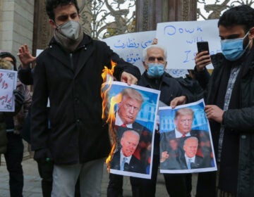 Iranian protesters burn images of President Trump and President-elect Joe Biden during a rally Saturday in Tehran