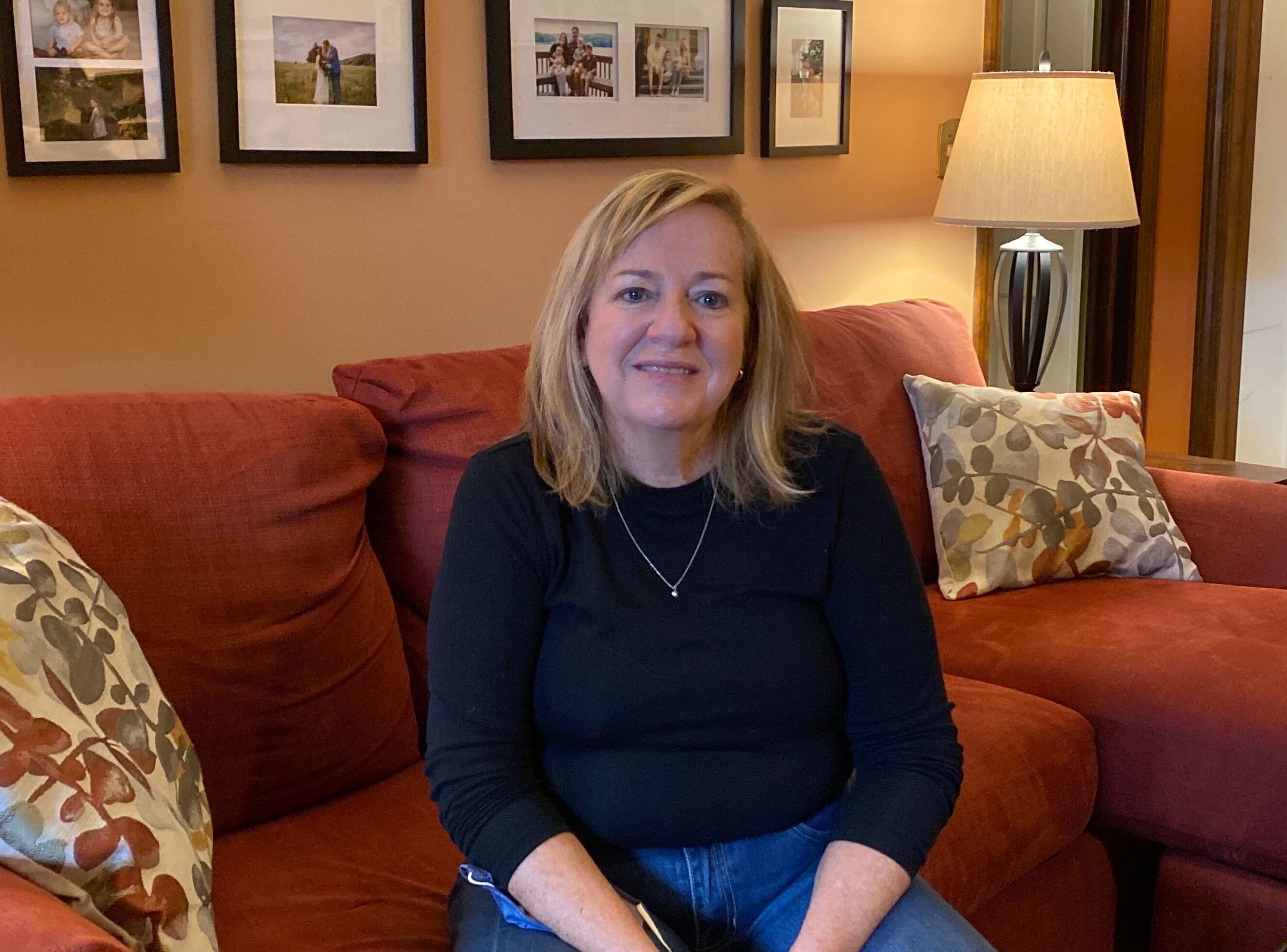 Maryann Frontino sits on a couch