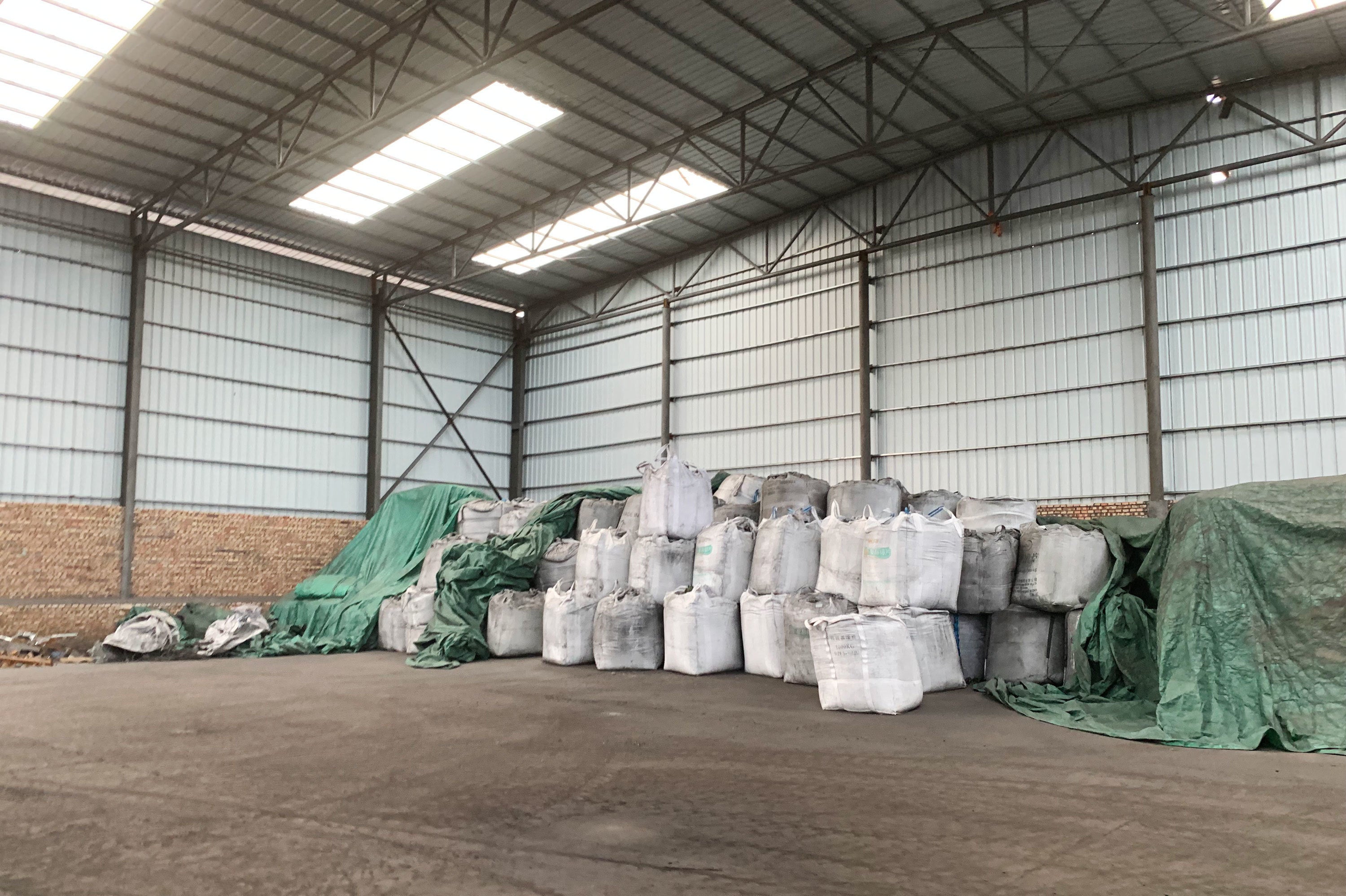 Sacks of coal byproducts await sale at a manufacturing site in northwestern China's Ningxia region, where Benjamin Chen works as a salesperson. 