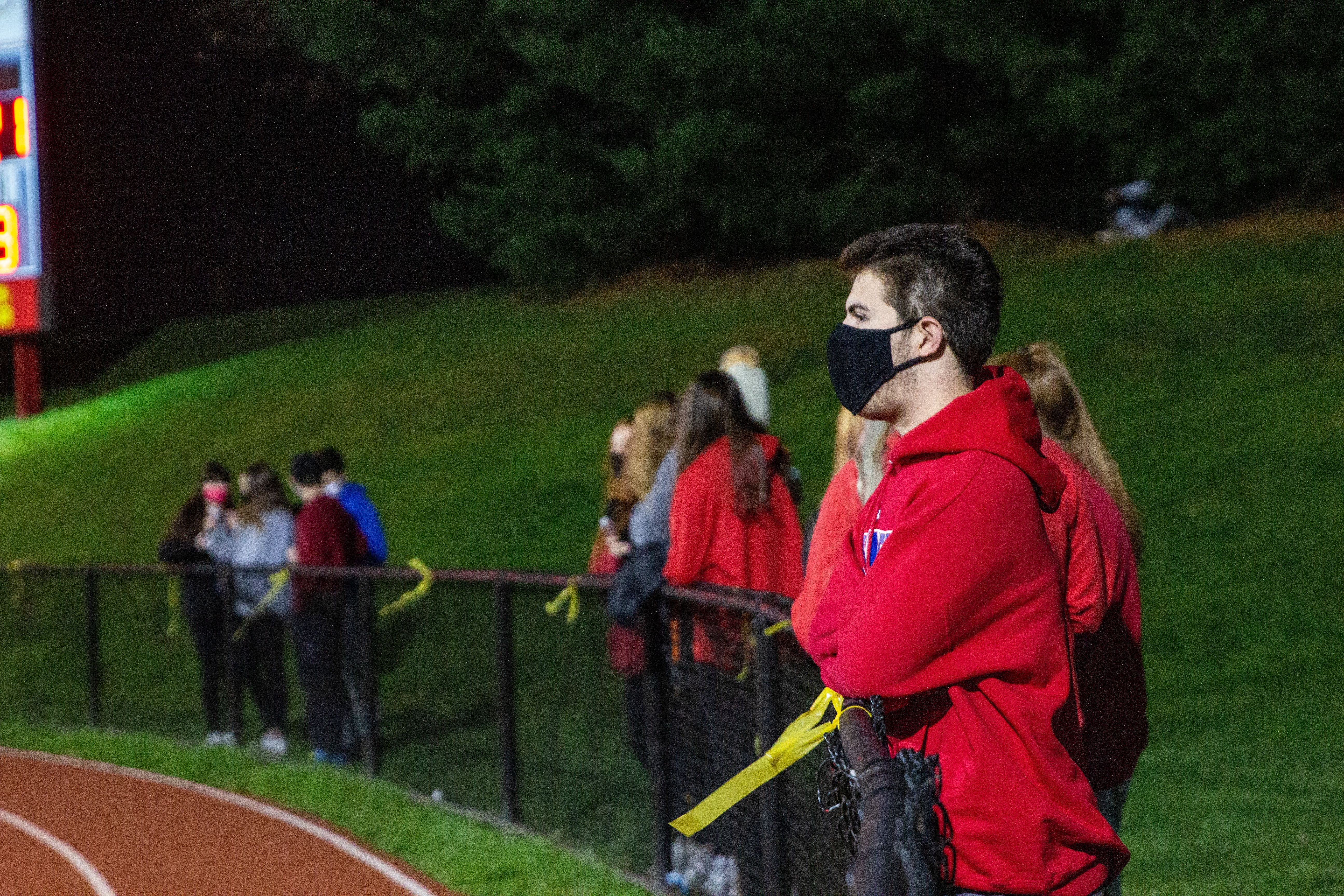 Student spectators from Penncrest High School watch the Media Bowl masked and distanced Friday.