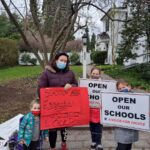Jennifer Singer with her children, protesting Montgomery County's two-week shutdown