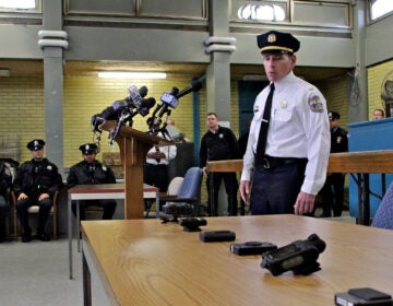 Lt. Tom McLean displays the array body camera models the police department tested when the the program began in 2014. (Emma Lee/WHYY, file)