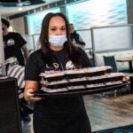 Christina Mclendon carries a plate of food during a giveaway event