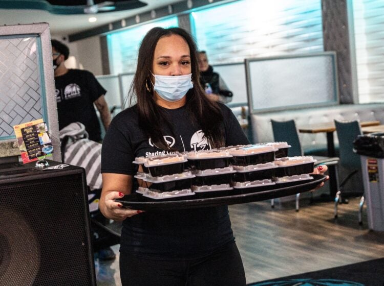 turkey_giveaway_KP_111520_06 Christina Mclendon carries a plate of food during a giveaway event