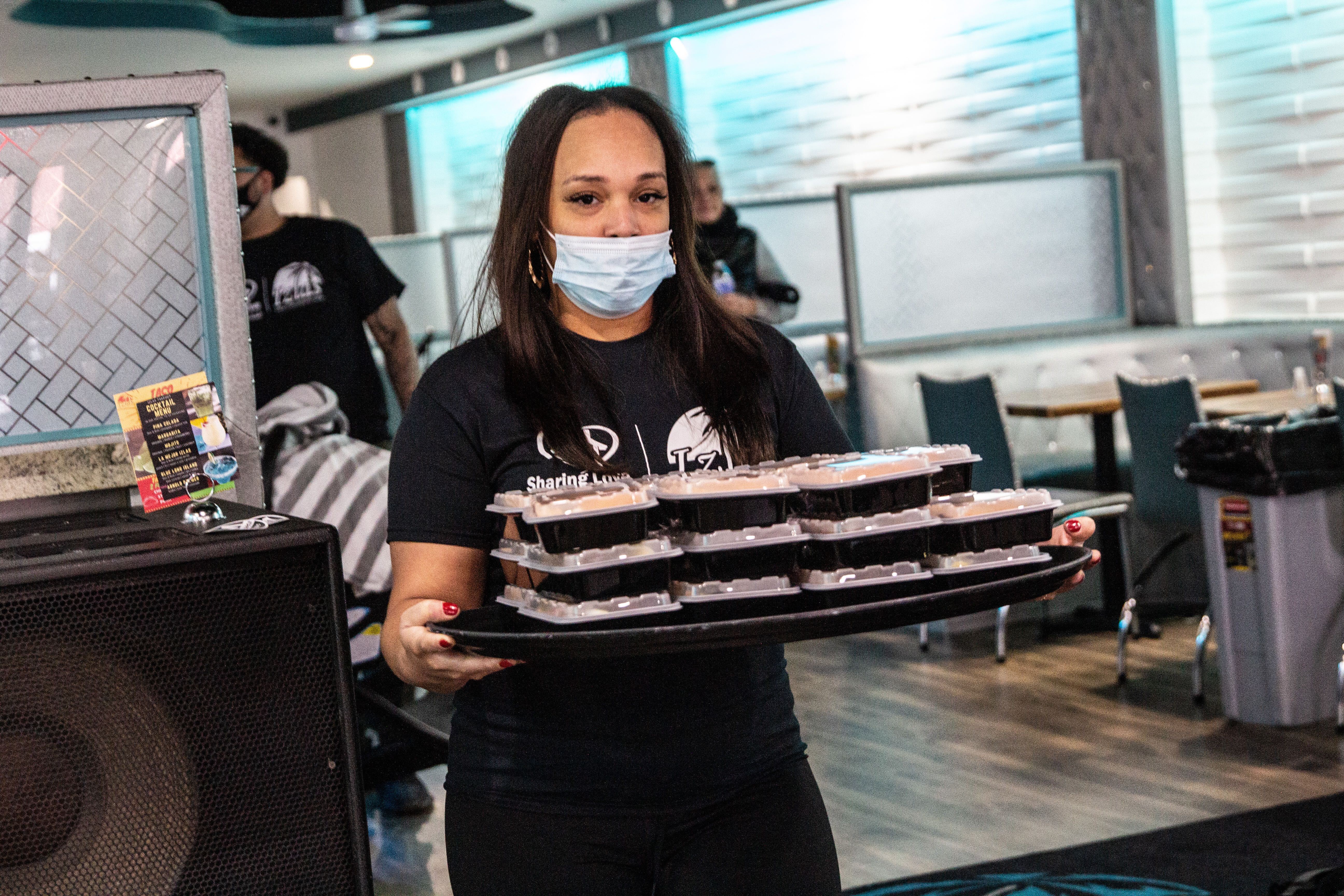 Christina Mclendon carries a plate of food during a giveaway event