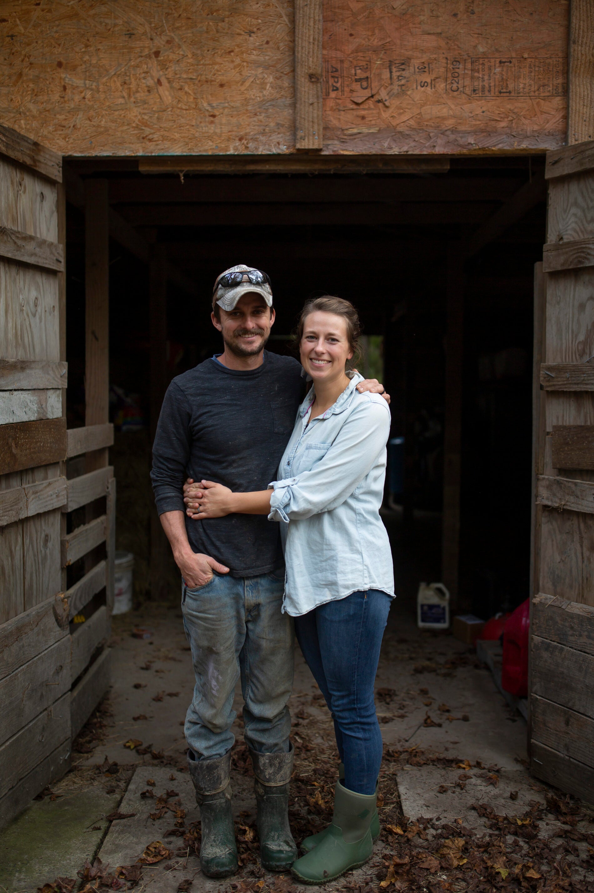 Joe Shenk, left, and Rachel Shenk, right, stand on their farm in Newport, N.C., on Nov. 15, 2020. The Shenks started their farm in 2017 with a desire to create a life that allowed them to focus on working together as a family. They now farm turkeys, chickens, and pigs. They hope to add cows in the near future as they continue to farm full-time. [Madeline Gray for NPR]