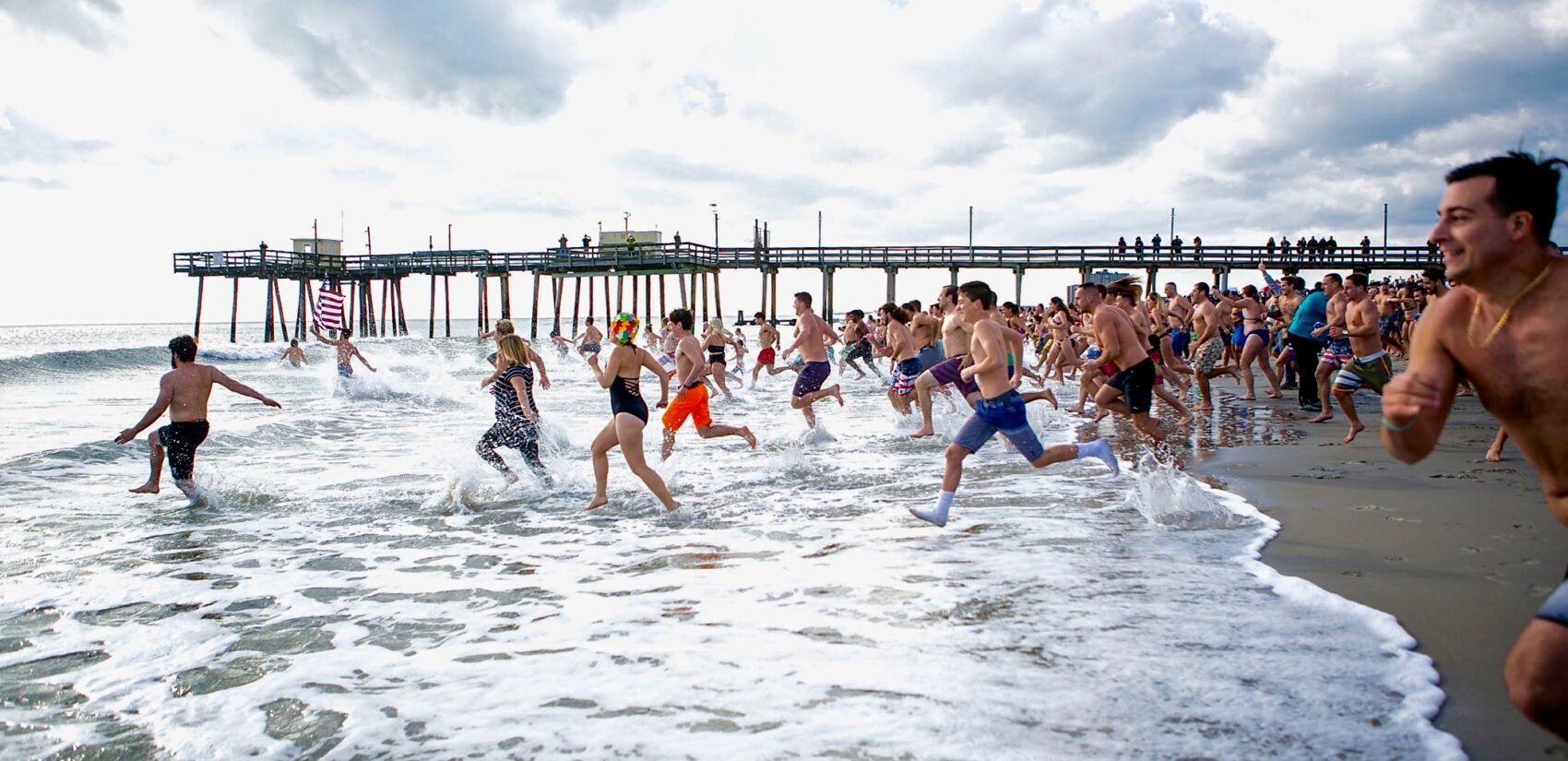 Participants of the 2020 polar bear plunge in Margate, N.J., run to the ocean on Wednesday, Jan. 1, 2020. (Miguel Martinez for WHYY)