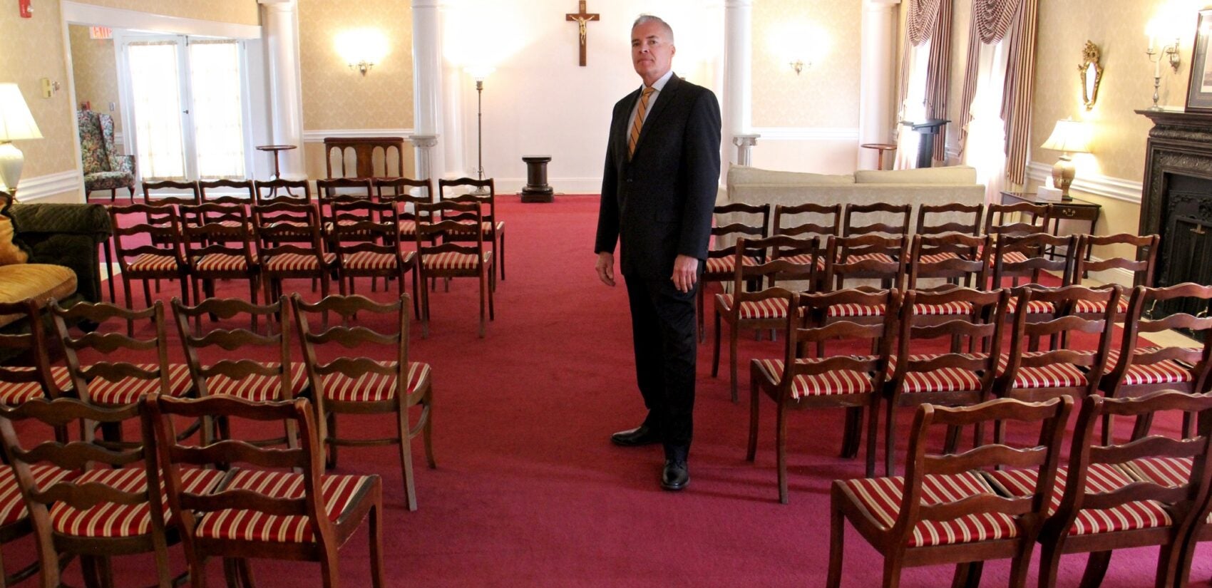 Funeral director Kurt Larsen stands in the empty chapel at Volk Leber Funeral Home in Teaneck, N.J. The chapel hasn't been used since limits on social gatherings went into effect for the region. (Emma Lee/WHYY)