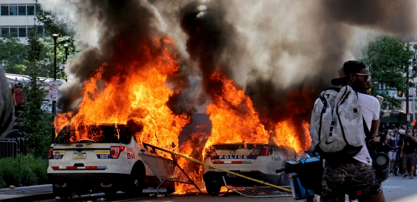 Police cars burn in front of City Hall on May 30, 2020. (Emma Lee/WHYY)