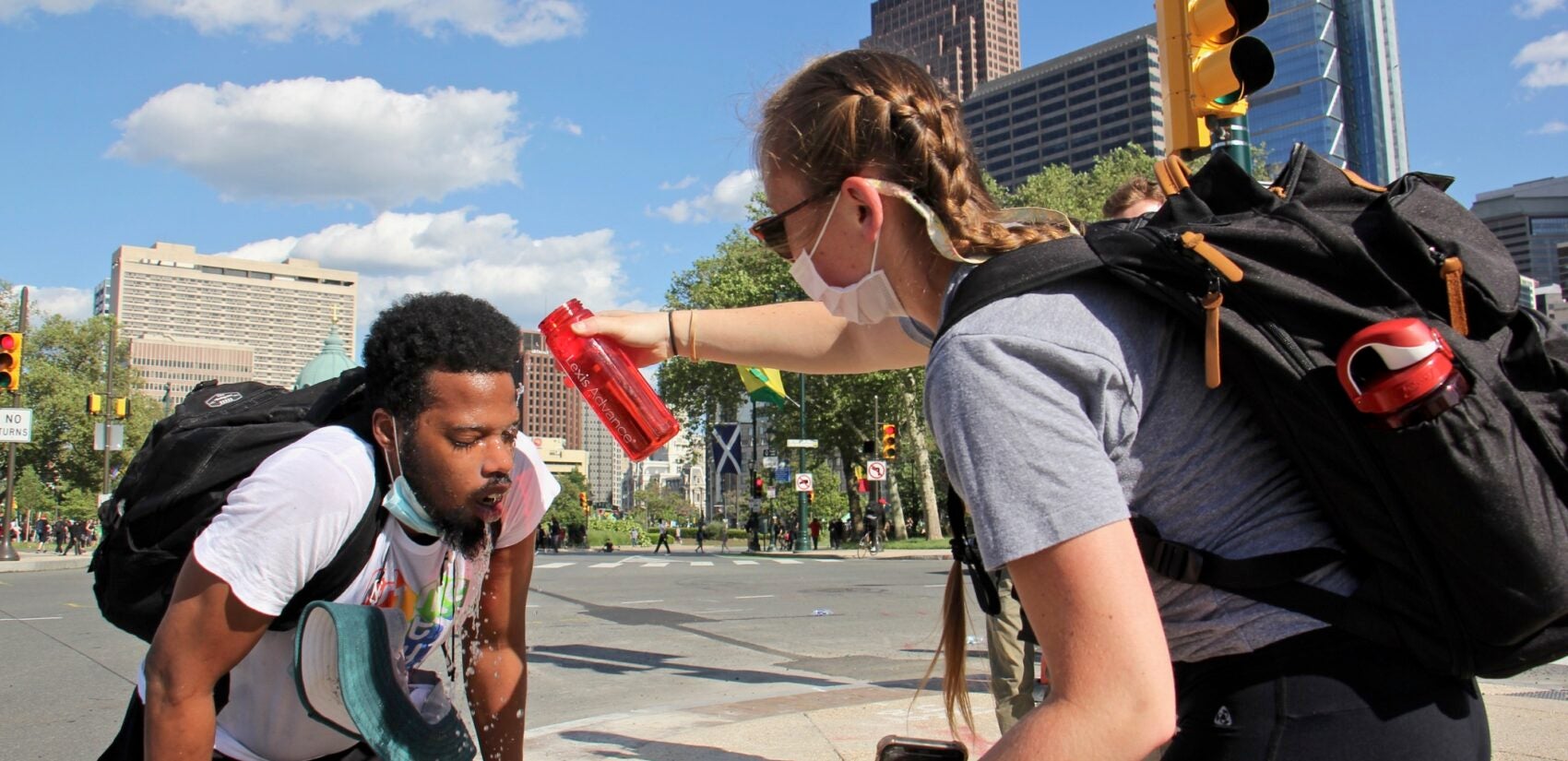 Protesters help each other after being tear gassed on the Ben Franklin Parkway, June 1, 2020. (Emma Lee/WHYY)