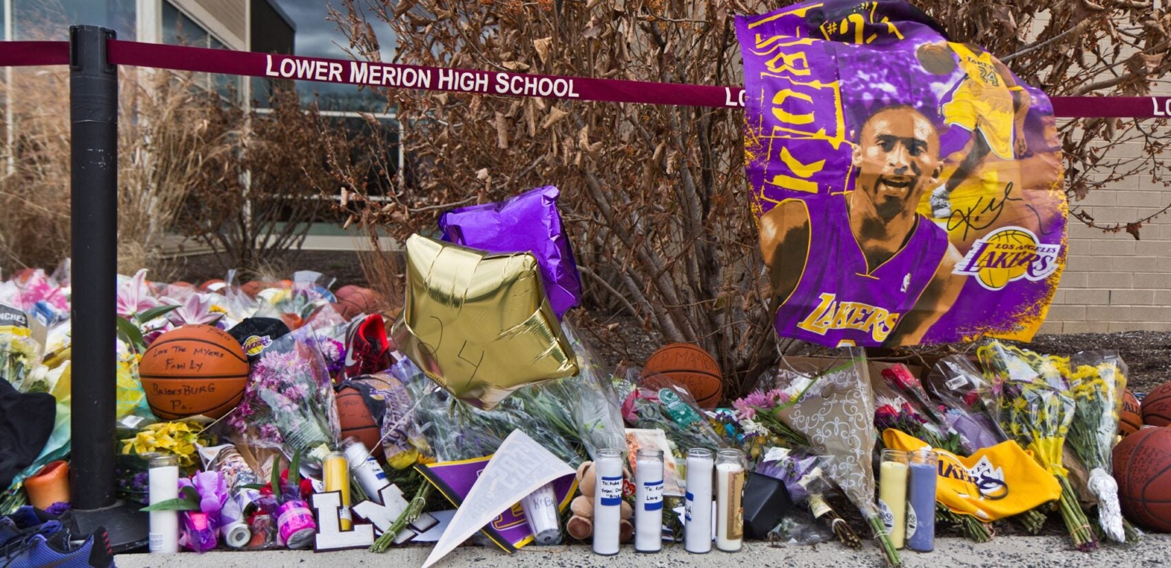 A memorial for late basketball superstar Kobe Bryant grows outside the Lower Merion high school gymnasium named for him. (Kimberly Paynter/WHYY)