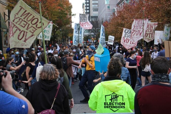 Protesters dance in the street outside the Pennsylvania Convention Center, where Philadelphia's mail and absentee ballots are being counted on Nov. 5, 2020. (Emma Lee/WHYY)