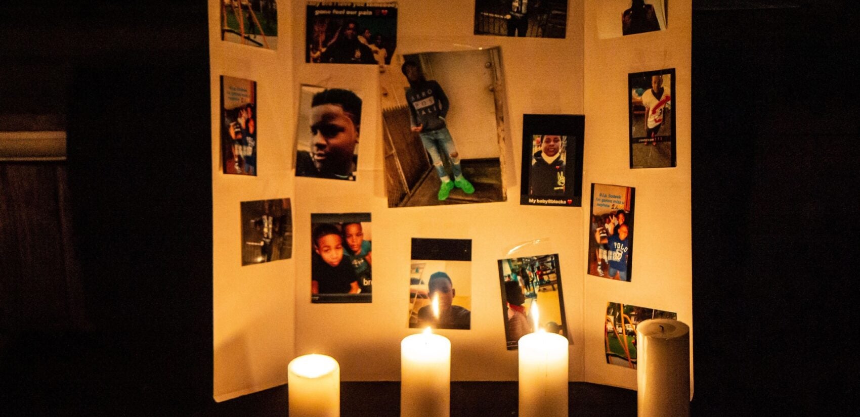 Photos of 12-year-old Sadeek Clark-Harrison and candles honor his life on his porch in Frankford. (Kimberly Paynter/WHYY)