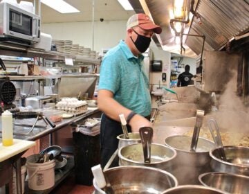 Mike Grafenstine works in the kitchen of his restaurant in Abington, Pa. (Emma Lee/WHYY)