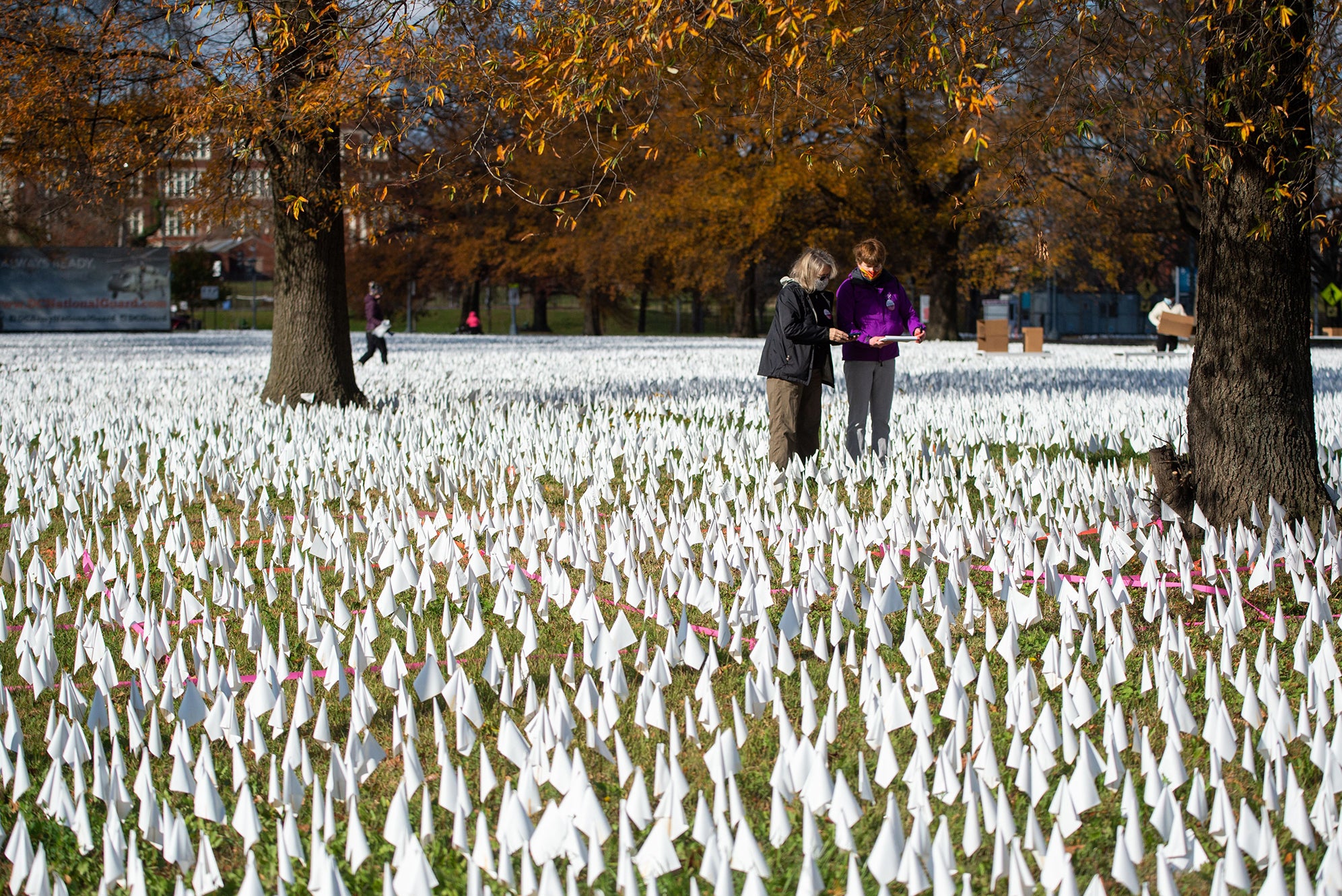 Dozens of volunteers helped geotag and collect flags in a recent art installation in Washington. Some flags were personalized with inscriptions by family members or friends of those who died.