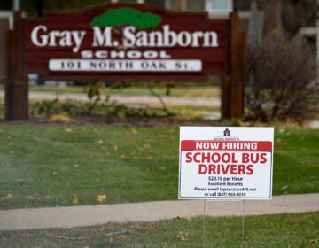 A hiring sign shows outside of Gray M. Sanborn Elementary School in Palatine, Ill., Thursday, Nov. 5, 2020. Illinois reports biggest spike in unemployment claims of all states. On Wednesday, Dec. 23, the number of Americans seeking unemployment benefits fell by 89,000 last week to a still-elevated 803,000, evidence that the job market remains under stress nine months after the coronavirus outbreak sent the U.S. economy into recession and caused millions of layoffs.  (AP Photo/Nam Y. Huh)