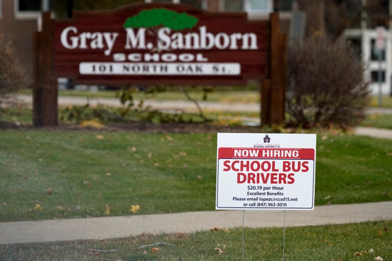 A hiring sign shows outside of Gray M. Sanborn Elementary School in Palatine, Ill., Thursday, Nov. 5, 2020. Illinois reports biggest spike in unemployment claims of all states. On Wednesday, Dec. 23, the number of Americans seeking unemployment benefits fell by 89,000 last week to a still-elevated 803,000, evidence that the job market remains under stress nine months after the coronavirus outbreak sent the U.S. economy into recession and caused millions of layoffs.  (AP Photo/Nam Y. Huh)