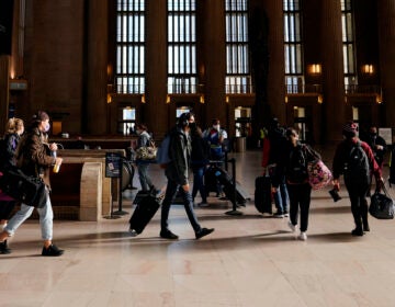 Travelers wait in line to board a train at the 30th Street Station ahead of the Thanksgiving holiday, Friday, Nov. 20, 2020, in Philadelphia. (AP Photo/Matt Slocum)