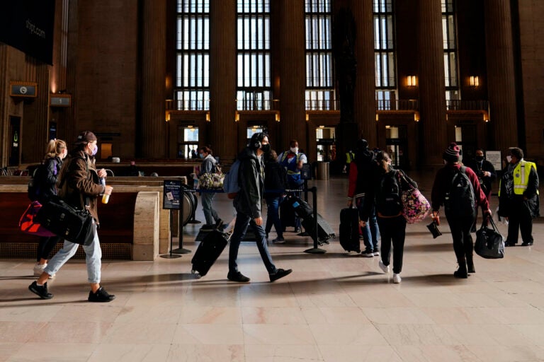 Travelers wait in line to board a train at the 30th Street Station ahead of the Thanksgiving holiday, Friday, Nov. 20, 2020, in Philadelphia. (AP Photo/Matt Slocum)