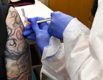 In this July 27, 2020, file photo, Nurse Kathe Olmstead, right, gives volunteer Melissa Harting, of Harpersville, N.Y., an injection as a study of a possible COVID-19 vaccine, developed by the National Institutes of Health and Moderna Inc., gets underway in Binghamton, N.Y. (AP Photo/Hans Pennink)