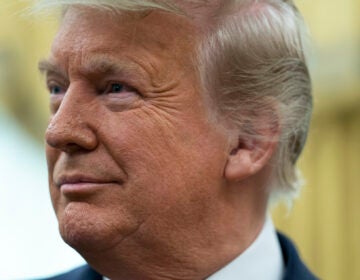 President Donald Trump listens during a ceremony to present the Presidential Medal of Freedom to former football coach Lou Holtz, in the Oval Office of the White House, Thursday, Dec. 3, 2020, in Washington. (AP Photo/Evan Vucci)