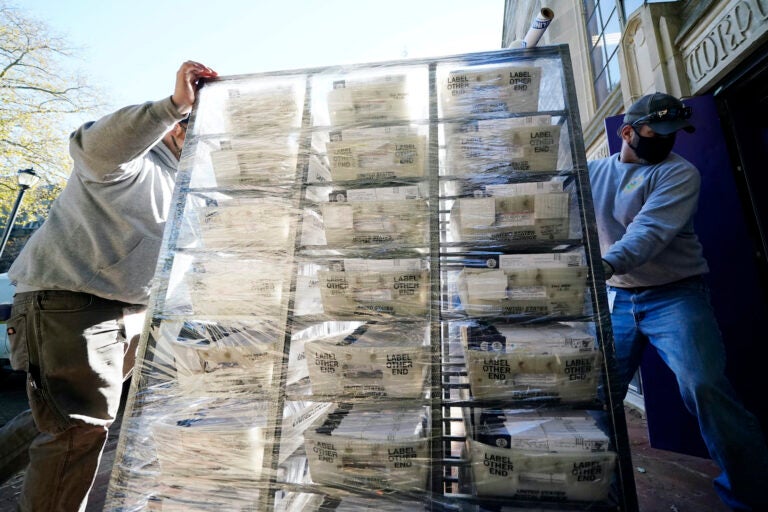 In this Wednesday, Nov. 4, 2020 file photo, Chester County workers transport mail-in and absentee ballots to be processed at West Chester University in West Chester, Pa. (AP Photo/Matt Slocum)