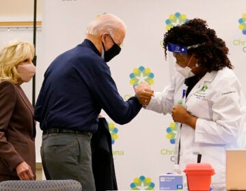 President-elect Joe Biden fist bumps with nurse practitioner Tabe Mase after receiving his first dose of the coronavirus vaccine at ChristianaCare Christiana Hospital in Newark, Del., Monday, Dec. 21, 2020, as Jill Biden looks on. (AP Photo/Carolyn Kaster)