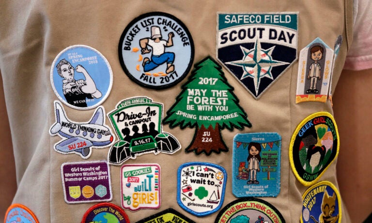 Patches cover the back of a Girl Scout's vest