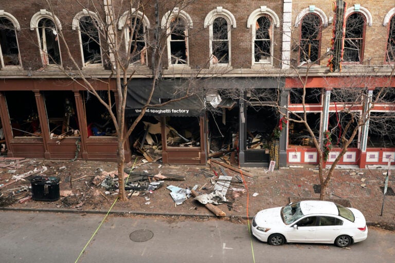 In this Dec. 29, 2020 file photo, debris remains on the sidewalk in front of buildings damaged in a Christmas Day explosion  in Nashville, Tenn. (AP Photo/Mark Humphrey)