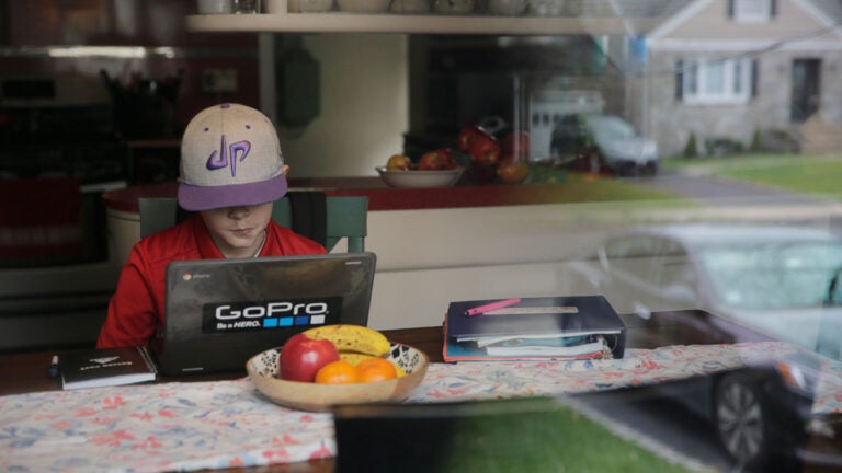 A young student attends virtual school from his home