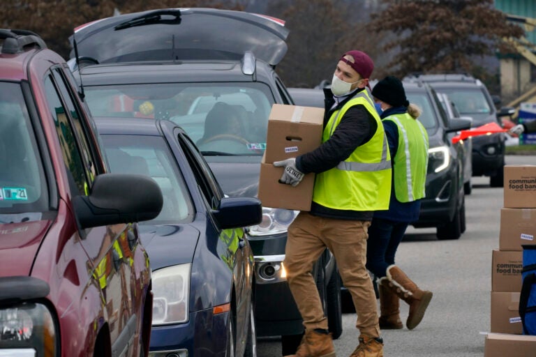 Volunteers load boxes of food into a car during a Greater Pittsburgh Community Food bank drive-up food distribution