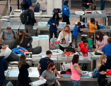 Travellers wear face masks while passing through the south security checkpoint in the main terminal of Denver International Airport