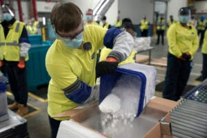 Dry ice is poured into a box containing the Pfizer-BioNTech COVID-19 vaccine as it is prepared to be shipped at the Pfizer Global Supply Kalamazoo manufacturing plant