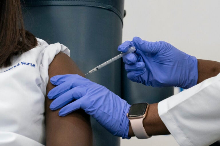 Sandra Lindsay, left, a nurse at Long Island Jewish Medical Center, is inoculated with the Pfizer-BioNTech COVID-19 vaccine by Dr. Michelle Chester