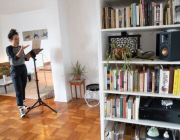 Netta Yerushalmy speaks to the other participants on her computer during a Zoom meeting dance rehearsal in her living room