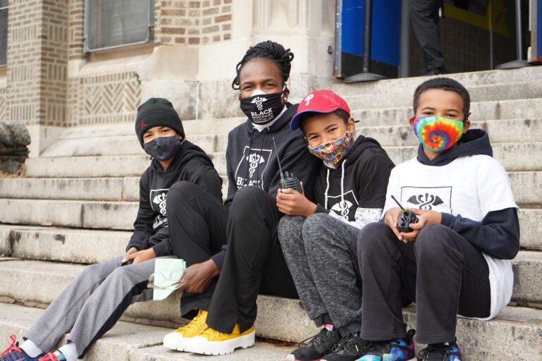 Dr. Ala Stanford, founder of the Black Doctors COVID-19 Consortium, sits outside of the testing event with her three sons who volunteered to help. (Kenny Cooper/WHYY)