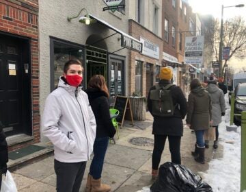 Nick Lukow waits in line to enter Ocassionate gift shop in South Philly. (Miles Bryan/WHYY)