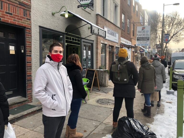 Nick Lukow waits in line to enter Ocassionate gift shop in South Philly. (Miles Bryan/WHYY)