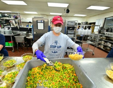 A volunteer prepares a meal via Catering by Design