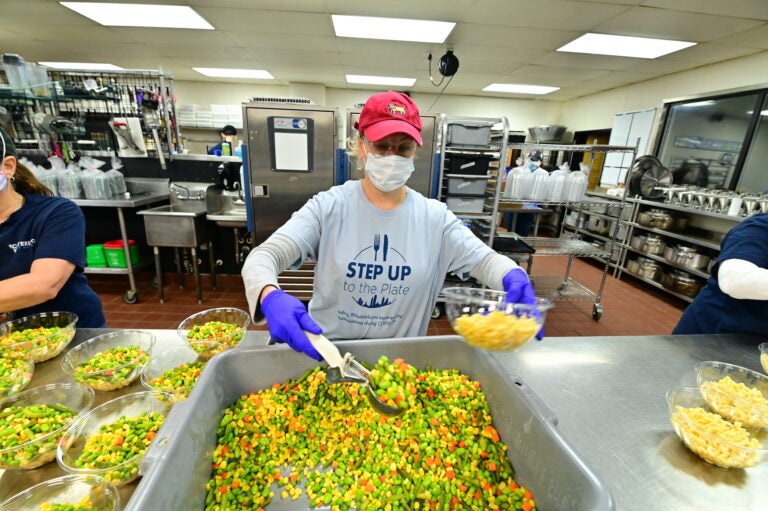 A volunteer prepares a meal via Catering by Design