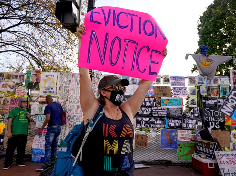 Jenn Katchmark, of Washington, holds up an eviction sign intended for Pres. Donald Trump while walking through Black Lives Matter Plaza