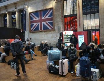 Passengers wearing face mask wait next to the Eurostar Terminal at Gare du Nord train station in Paris