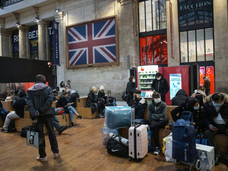 Passengers wearing face mask wait next to the Eurostar Terminal at Gare du Nord train station in Paris