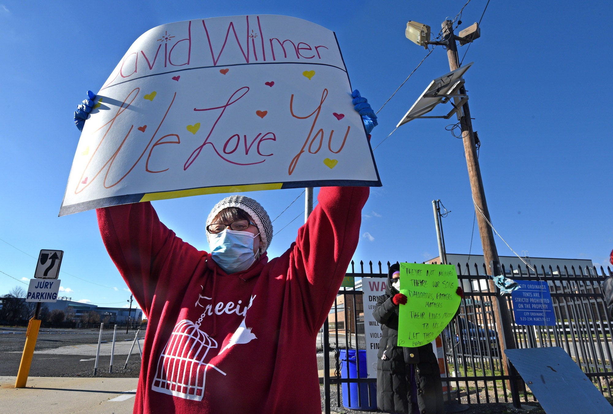 Dana Butler holds a sign of support for her incarcerated son, David Wilmer, outside the Camden County jail during a Dec. 6 protest