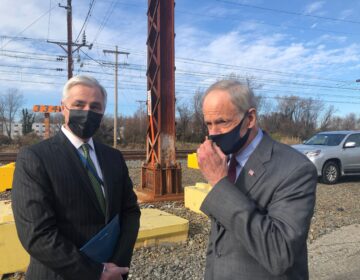 Amtrak chief executive Bill Flynn (left) and U.S. Sen. Tom Carper, D-Del., both hailed the completion of the project that added a third track along a 1 1/2-mile stretch from Wilmington to Newark. (Cris Barrish/WHYY)