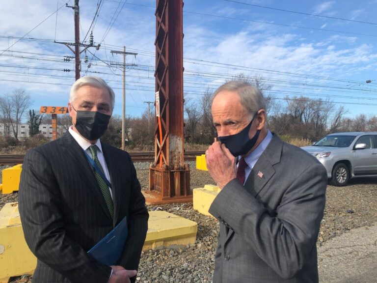 Amtrak chief executive Bill Flynn (left) and U.S. Sen. Tom Carper, D-Del., both hailed the completion of the project that added a third track along a 1 1/2-mile stretch from Wilmington to Newark. (Cris Barrish/WHYY)